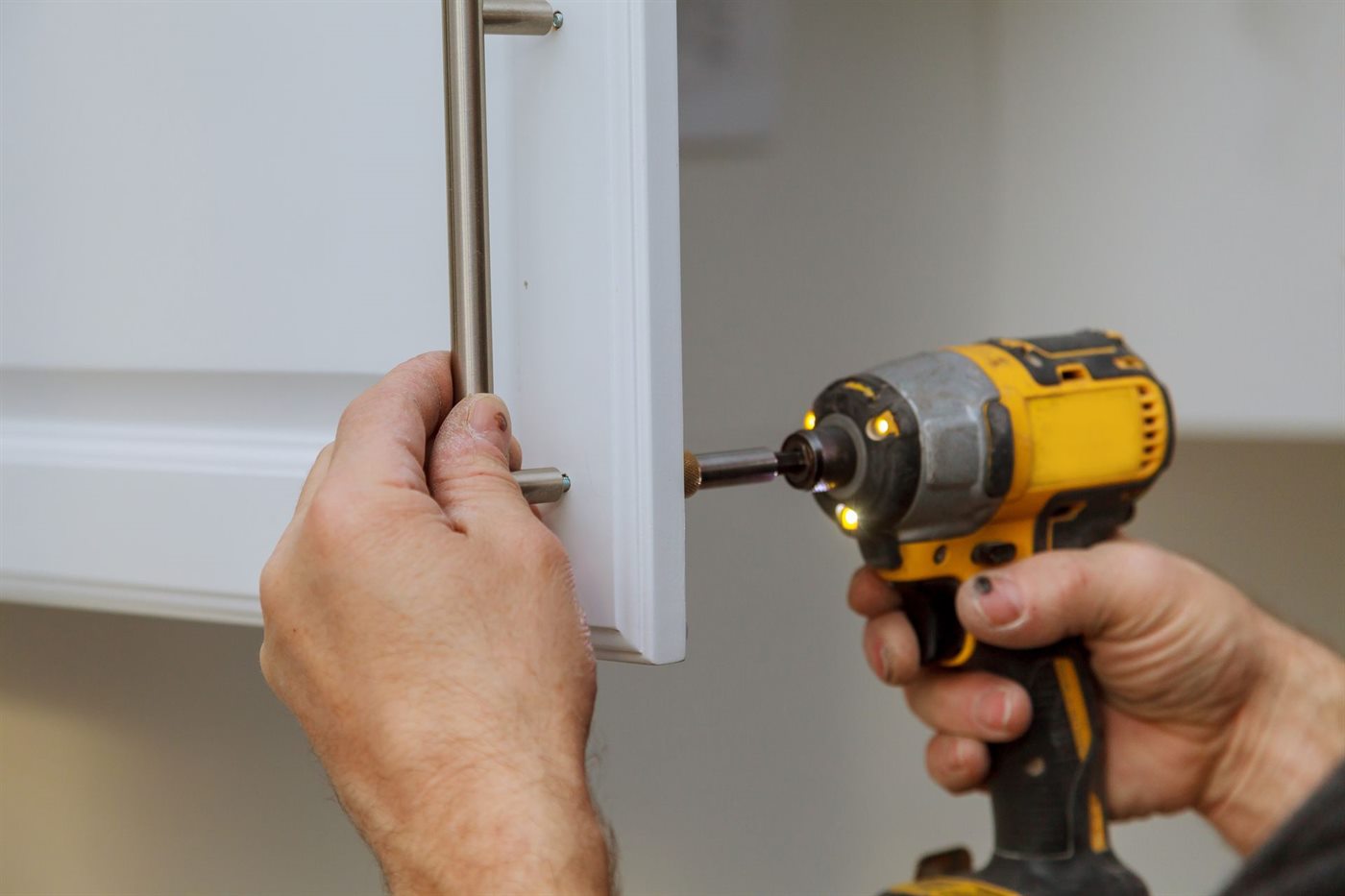Contractor installing wholesale kitchen cabinets on a Maryland jobsite